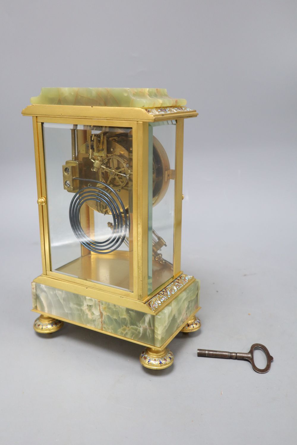 An early 20th century French green onyx, champleve enamel and ormolu mantel clock, includes key, height 27cm